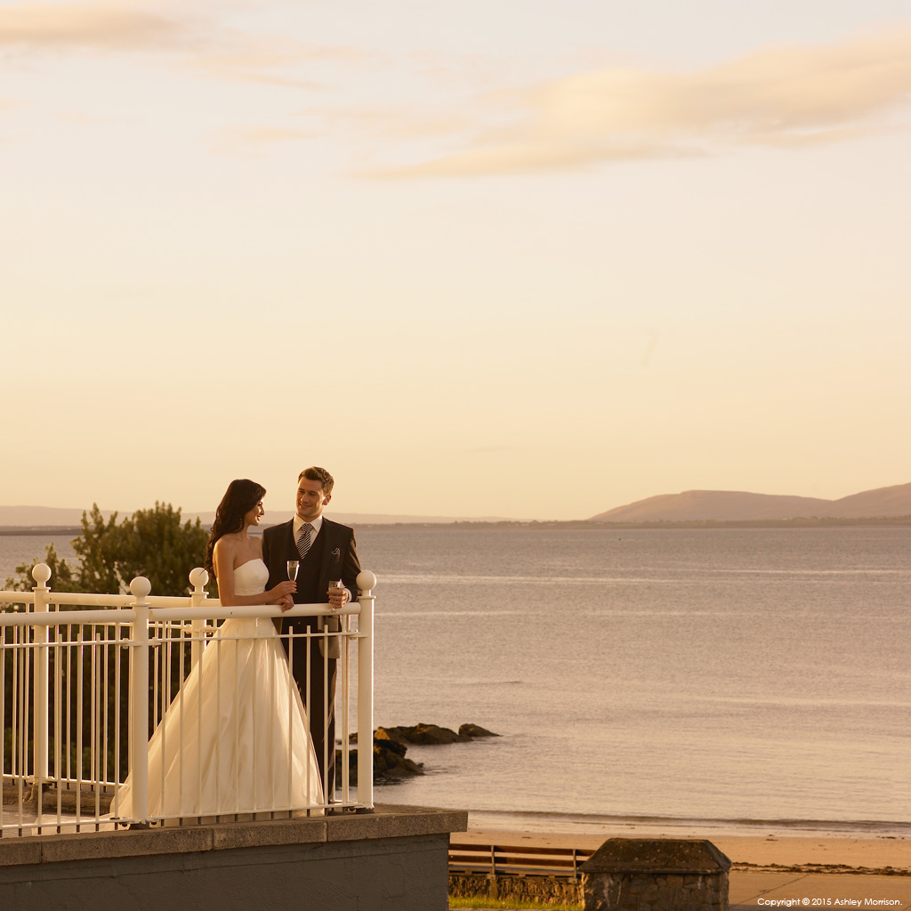 Bride and Groom standing on the balcony at the Galway Bay Hotel in Salthill.