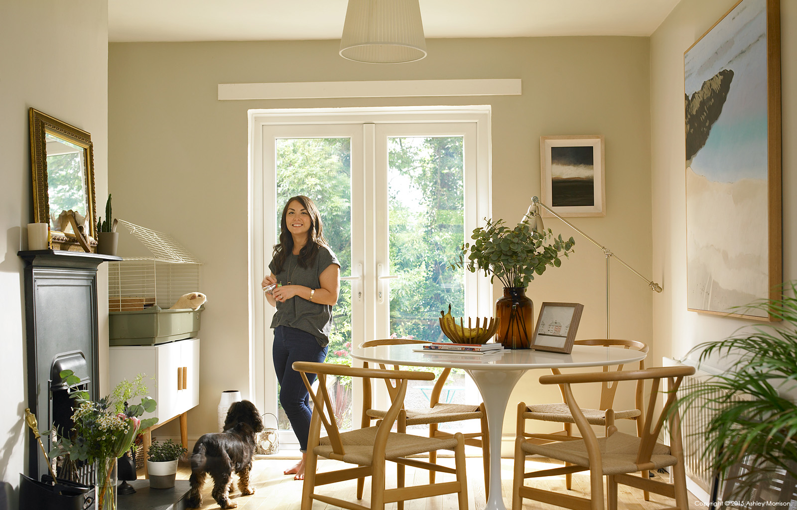 Michelle Blair with her dog called Charlie and guinea pig called Mr Tickles in the dining room area of her 1950's semi in the south of Belfast.