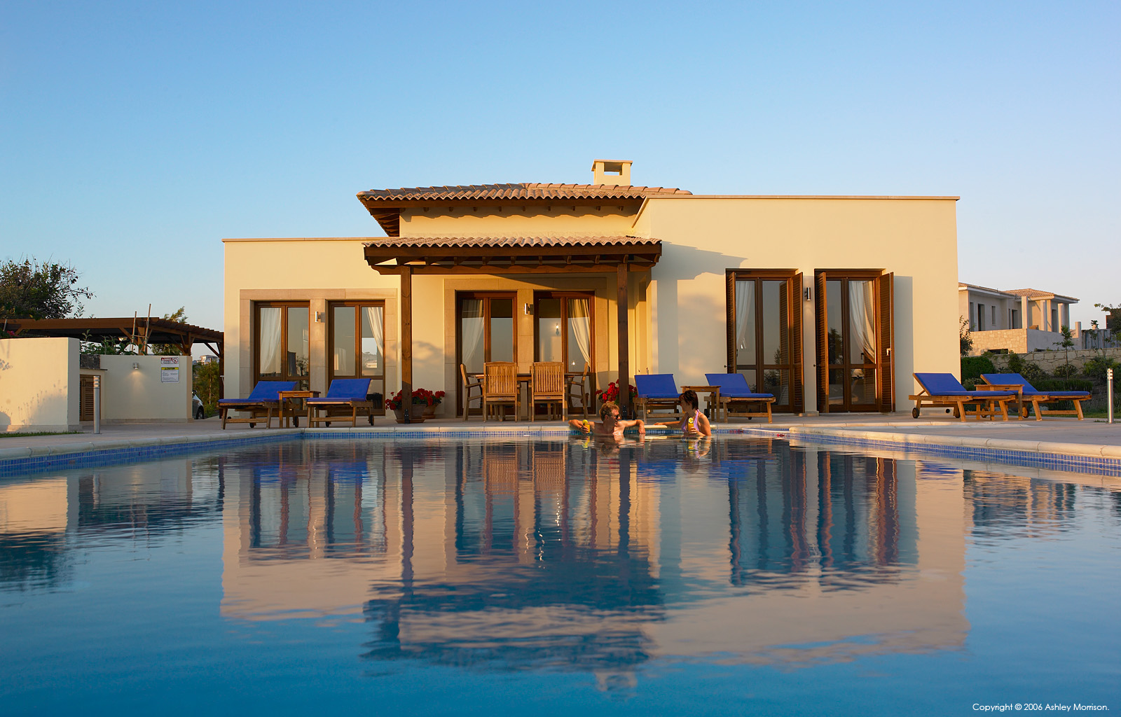 Karen & her husband enjoying the pool at John O'Callaghan's Villa Thalia in Aphrodite Hills near Paphos in Cyprus by Ashley Morrison.